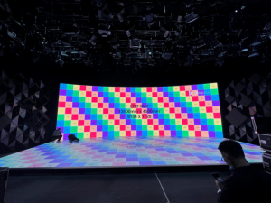 Curved LED wall and LED floor displaying a colour calibration checkerboard, labelled 13500mm by 4500mm at 5184 x 1728 pixels