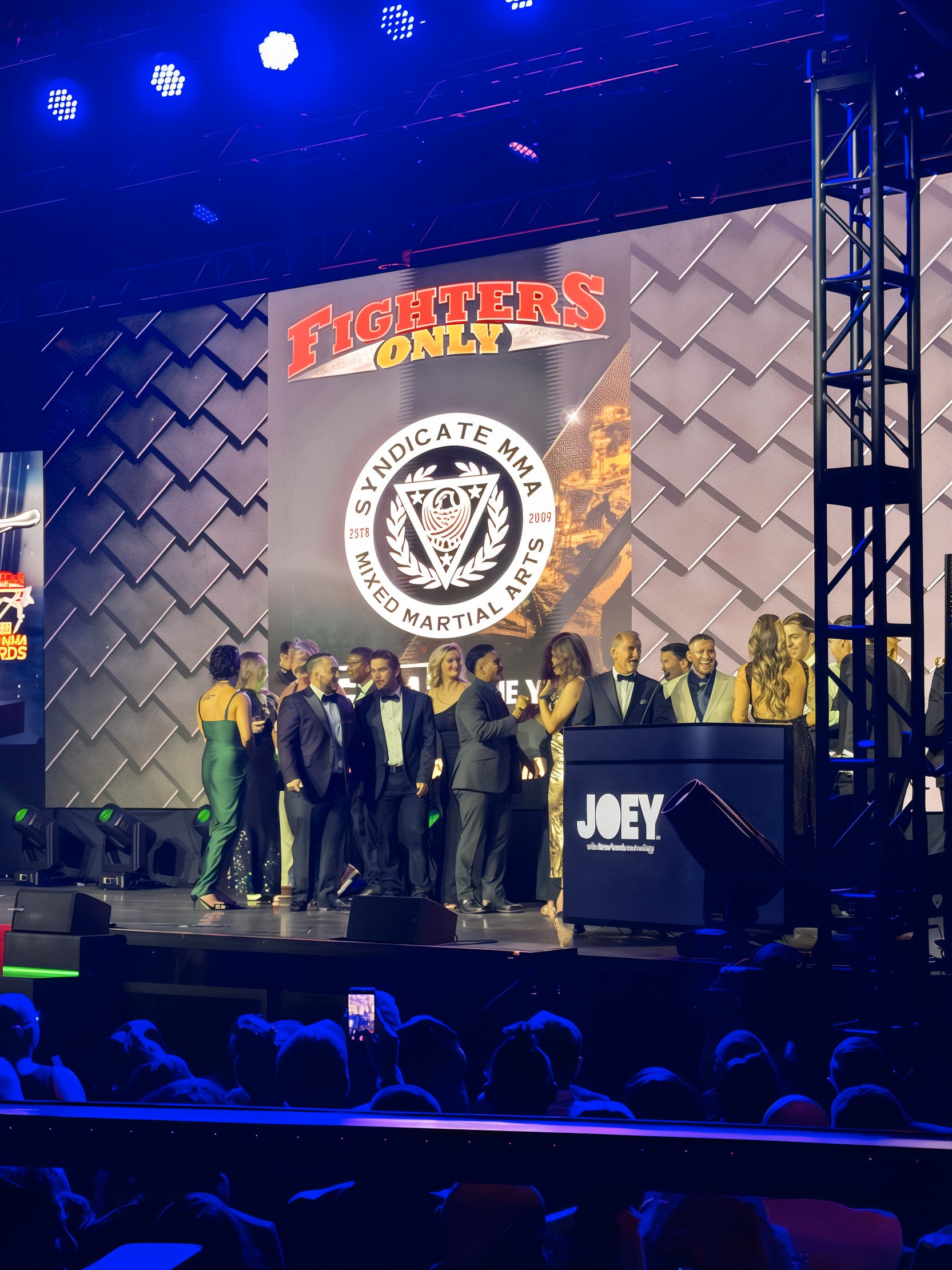 Group of presenters on stage at the HOLODECK HoloPod™ podium, branded for JOEY, 17th World MMA Awards