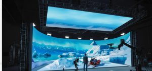 Curved LED ceiling display (HOLODECK HoloSky) over a virtual production stage showing an arctic scene