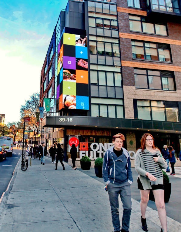 Vertical LED screen on the corner of a building marked 39-16 and One Fulton