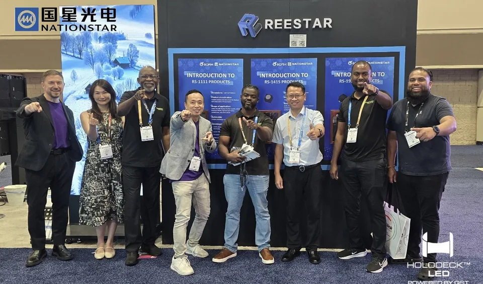 Group of event attendees in front of a trade show booth