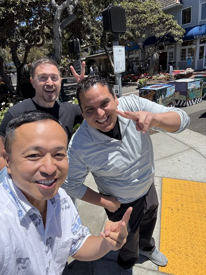 Three men outdoors giving thumbs up