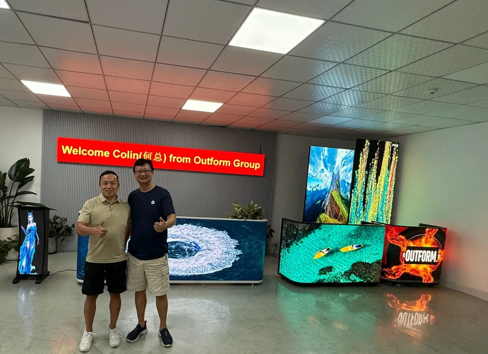 Two men standing beside showroom LED displays
