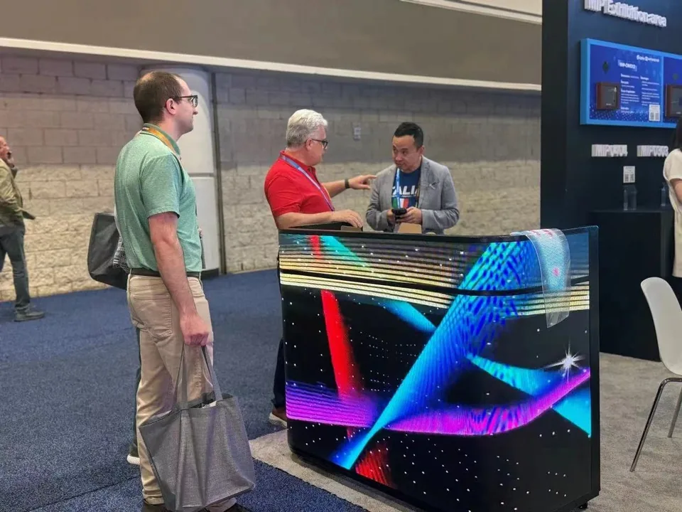 Three men around an LED demonstration counter