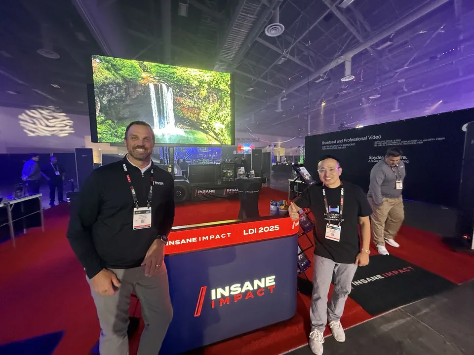 Three people at a large LED booth