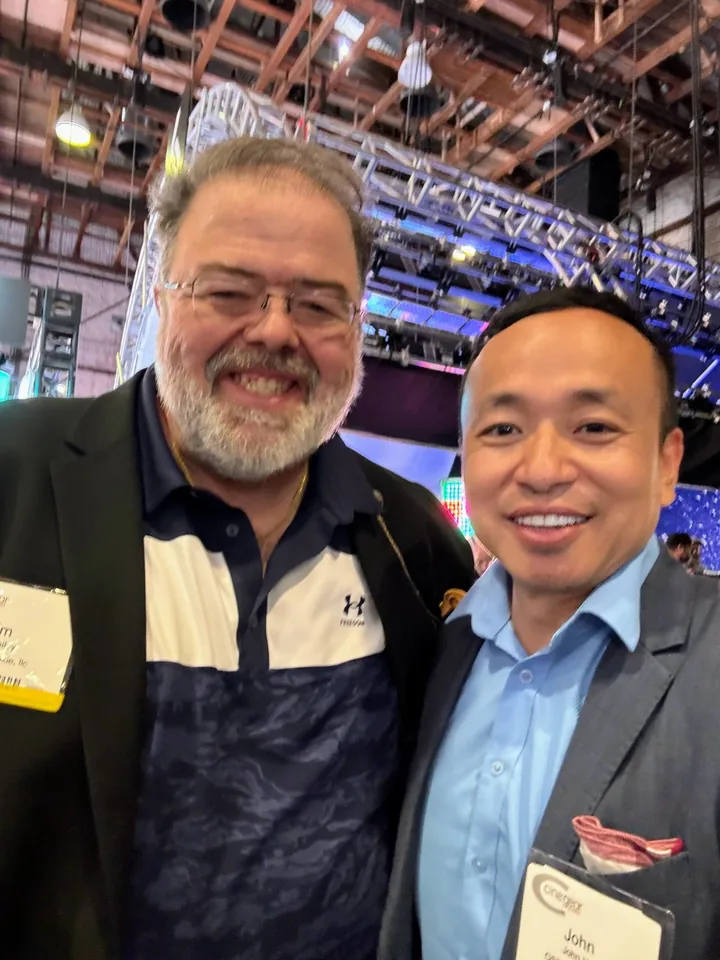 Two men taking a selfie on a trade show floor